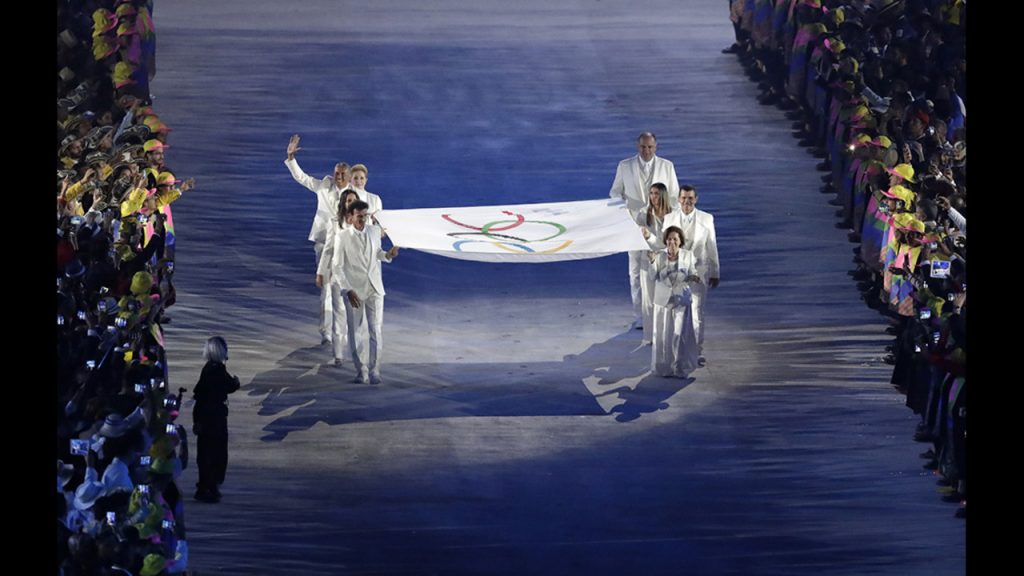 The Olympic flag is carried into the stadium [Photo: AP /Matthias Schrader]